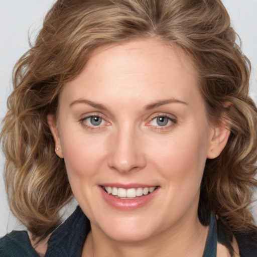 Joyful white adult female with medium  brown hair and blue eyes