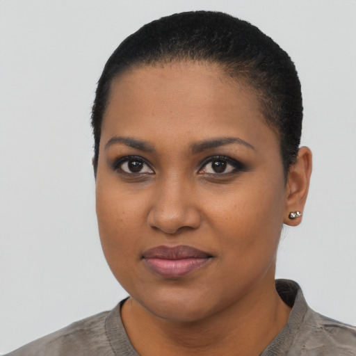 Joyful black young-adult female with short  black hair and brown eyes