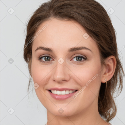 Joyful white young-adult female with medium  brown hair and green eyes