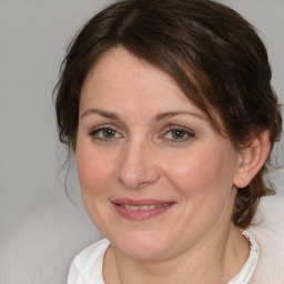 Joyful white young-adult female with medium  brown hair and blue eyes