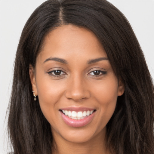 Joyful latino young-adult female with long  brown hair and brown eyes