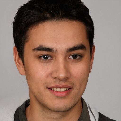 Joyful latino young-adult male with short  brown hair and brown eyes