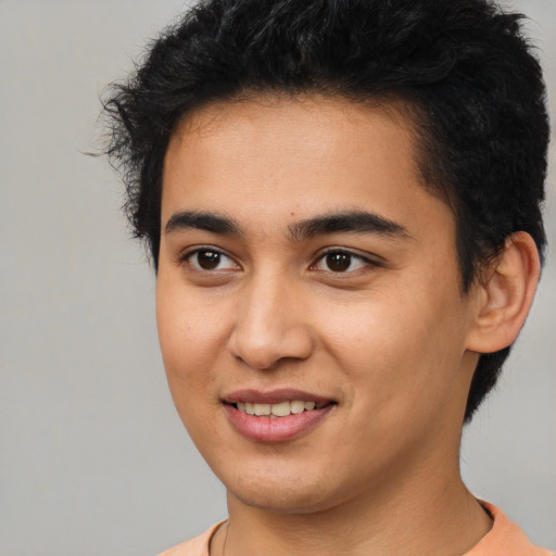 Joyful latino young-adult male with short  brown hair and brown eyes