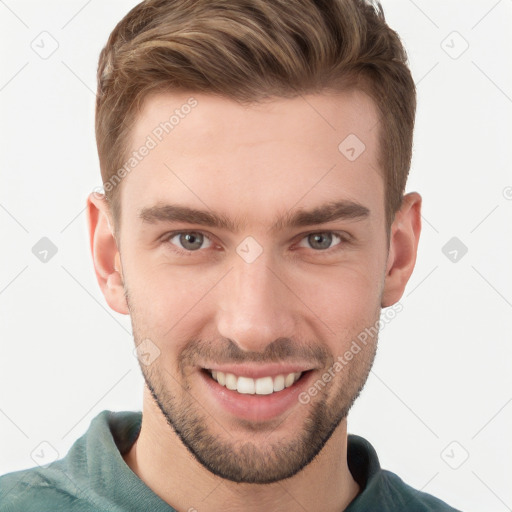 Joyful white young-adult male with short  brown hair and grey eyes