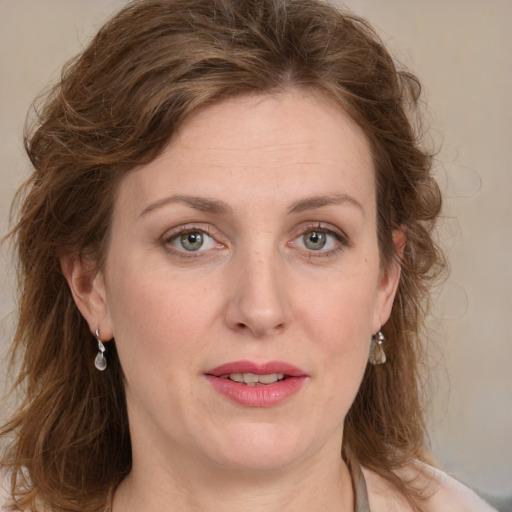 Joyful white adult female with medium  brown hair and blue eyes