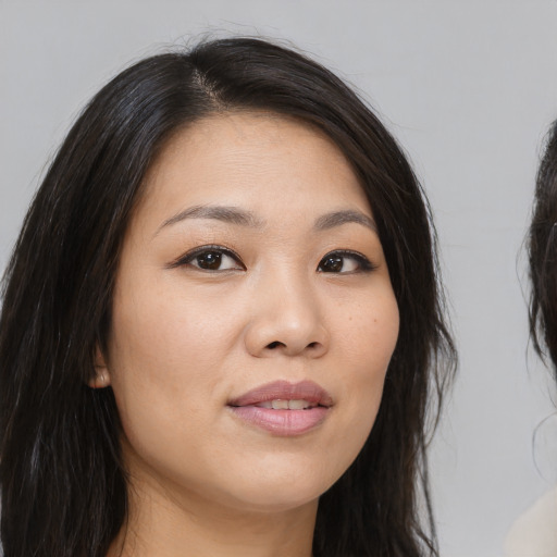 Joyful asian young-adult female with long  brown hair and brown eyes
