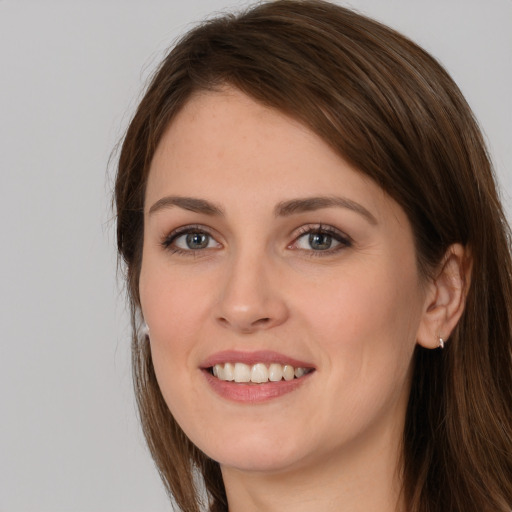 Joyful white young-adult female with long  brown hair and grey eyes