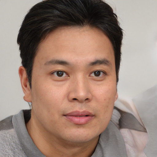 Joyful asian adult male with short  brown hair and brown eyes