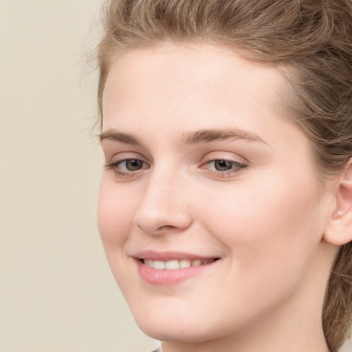 Joyful white young-adult female with long  brown hair and blue eyes