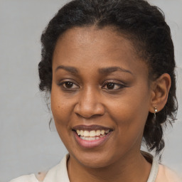 Joyful black adult female with medium  brown hair and brown eyes