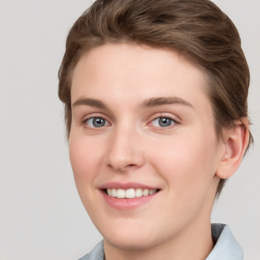 Joyful white young-adult female with short  brown hair and grey eyes