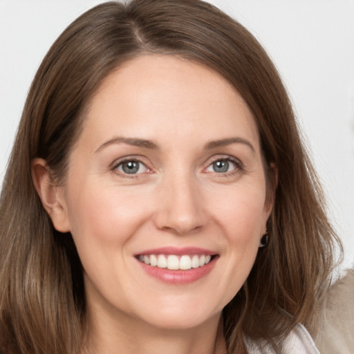 Joyful white young-adult female with long  brown hair and grey eyes