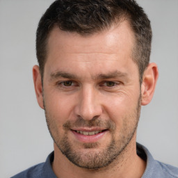 Joyful white adult male with short  brown hair and brown eyes