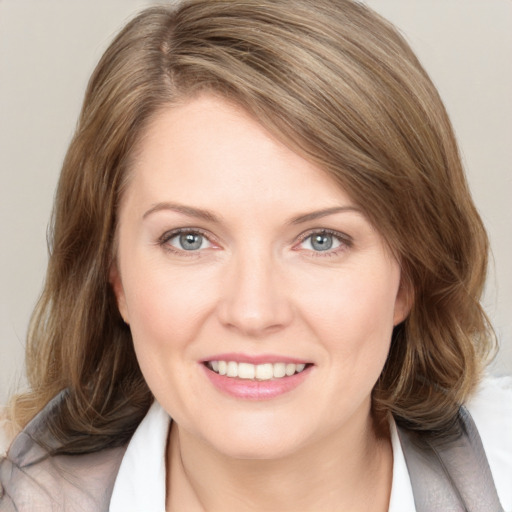 Joyful white young-adult female with medium  brown hair and blue eyes