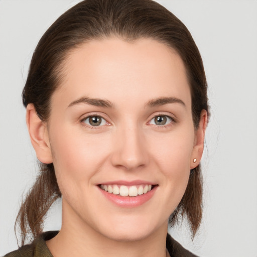 Joyful white young-adult female with medium  brown hair and grey eyes