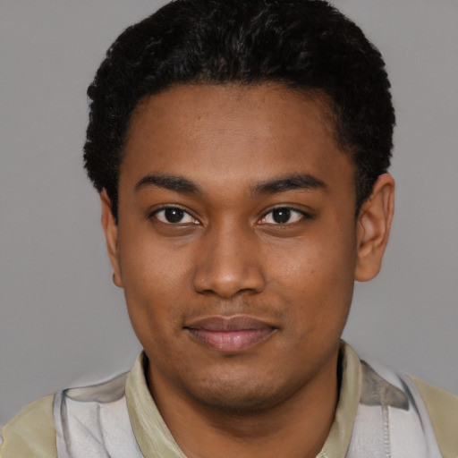 Joyful black young-adult male with short  black hair and brown eyes