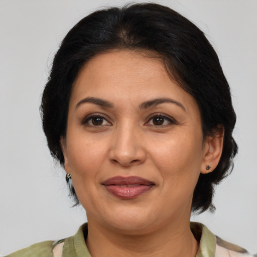 Joyful latino adult female with medium  brown hair and brown eyes