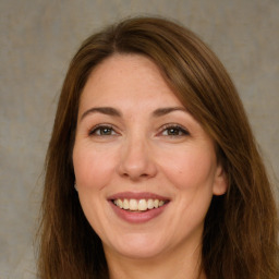 Joyful white adult female with long  brown hair and green eyes