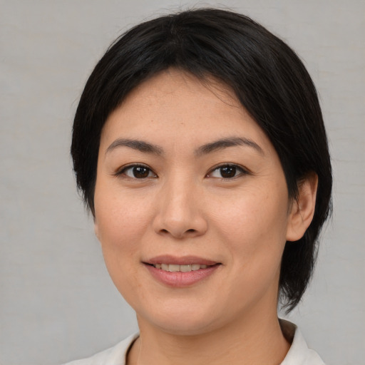 Joyful asian young-adult female with medium  brown hair and brown eyes