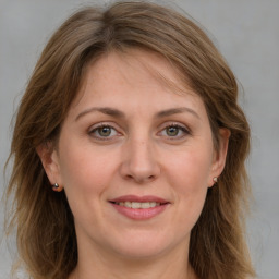 Joyful white adult female with medium  brown hair and grey eyes