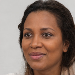 Joyful black adult female with long  brown hair and brown eyes