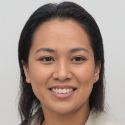 Joyful latino young-adult female with medium  brown hair and brown eyes