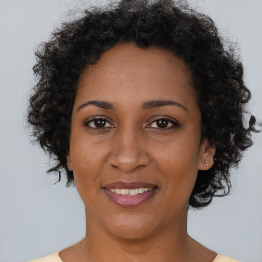 Joyful black adult female with short  brown hair and brown eyes