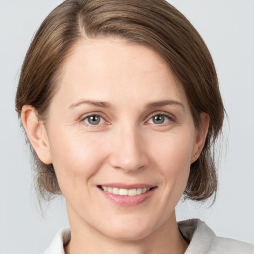 Joyful white young-adult female with medium  brown hair and grey eyes