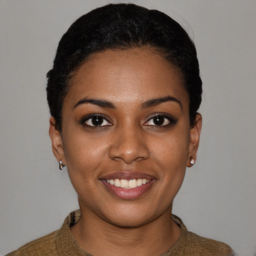 Joyful black young-adult female with short  black hair and brown eyes