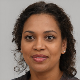 Joyful latino adult female with medium  brown hair and brown eyes