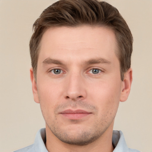 Joyful white young-adult male with short  brown hair and grey eyes