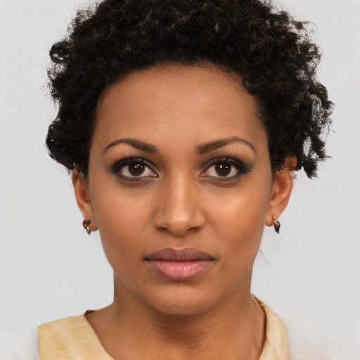 Joyful black young-adult female with short  brown hair and brown eyes