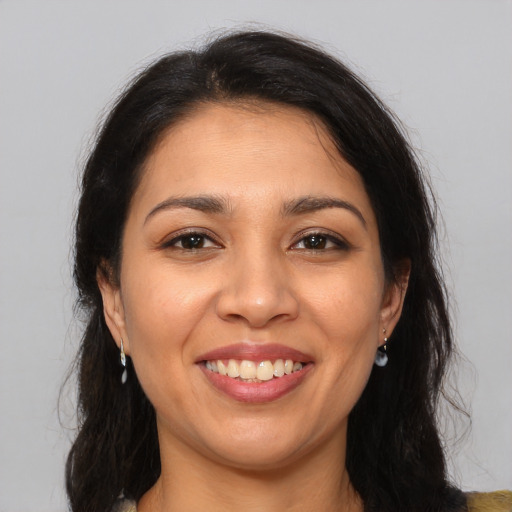 Joyful latino young-adult female with long  brown hair and brown eyes