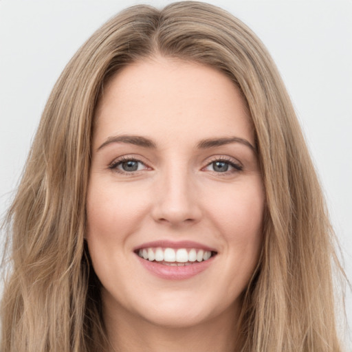 Joyful white young-adult female with long  brown hair and green eyes