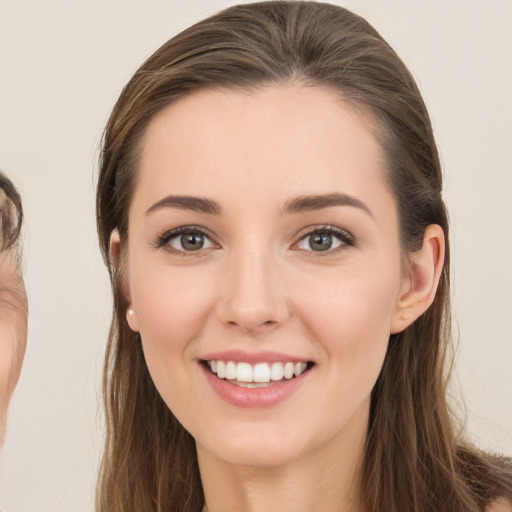 Joyful white young-adult female with long  brown hair and brown eyes