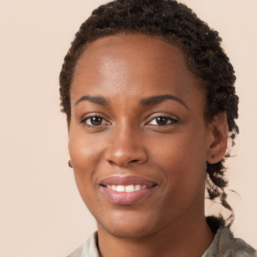 Joyful black young-adult female with short  brown hair and brown eyes