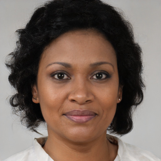 Joyful black adult female with medium  brown hair and brown eyes