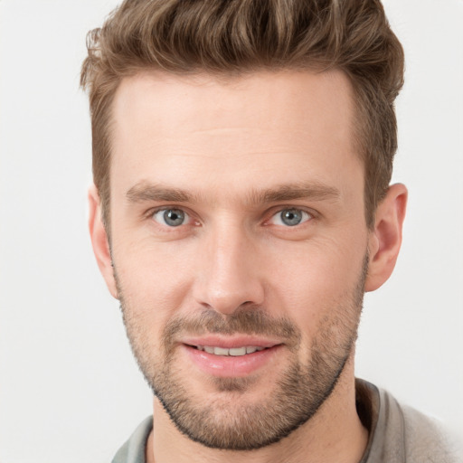 Joyful white young-adult male with short  brown hair and grey eyes