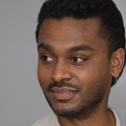 Joyful black young-adult male with short  black hair and brown eyes