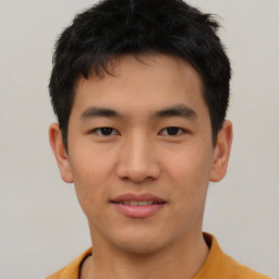 Joyful asian young-adult male with short  brown hair and brown eyes