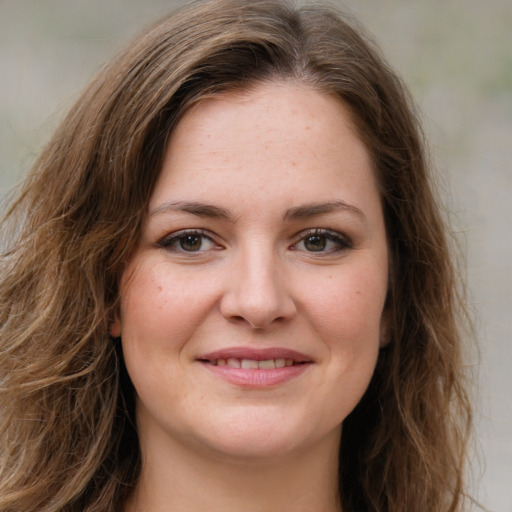 Joyful white young-adult female with long  brown hair and green eyes