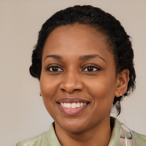 Joyful black young-adult female with short  black hair and brown eyes