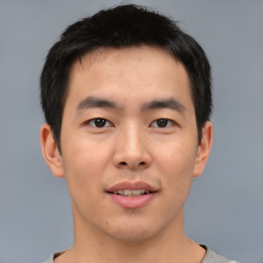 Joyful asian young-adult male with short  brown hair and brown eyes
