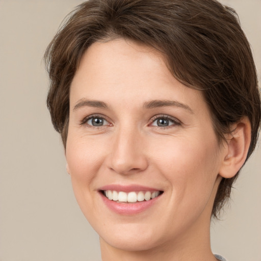 Joyful white young-adult female with medium  brown hair and green eyes