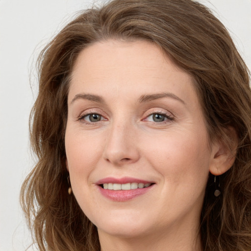 Joyful white young-adult female with long  brown hair and green eyes