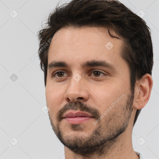 Joyful white young-adult male with short  black hair and brown eyes