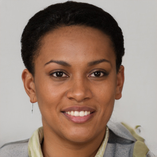 Joyful black young-adult female with short  brown hair and brown eyes