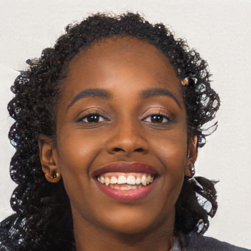 Joyful black young-adult female with long  brown hair and brown eyes