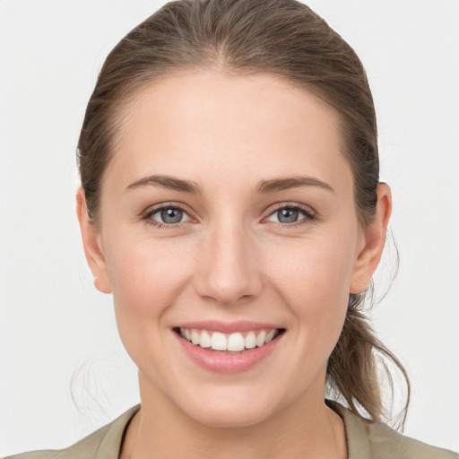 Joyful white young-adult female with medium  brown hair and grey eyes