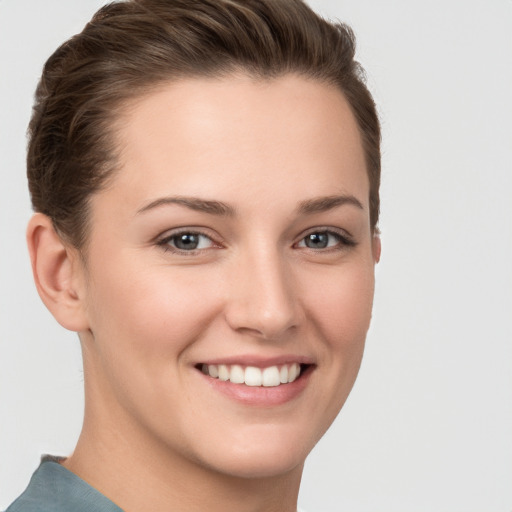 Joyful white young-adult female with short  brown hair and grey eyes